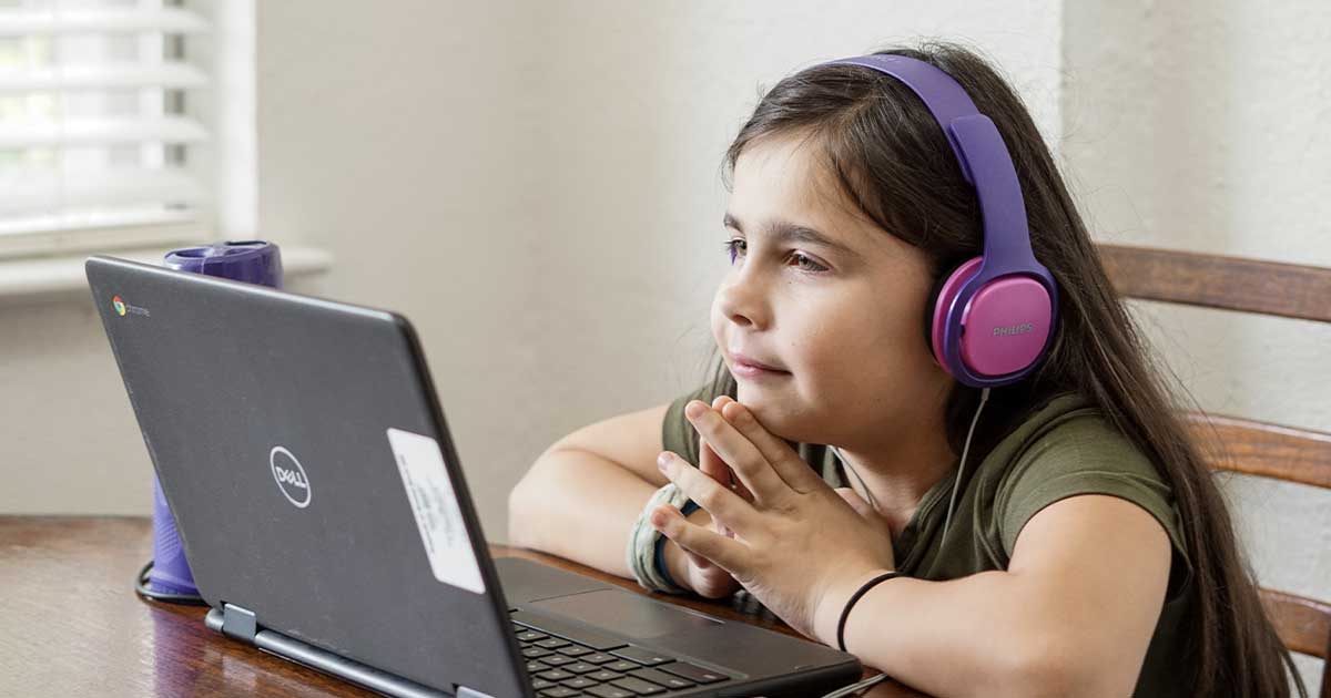 young girl with headphones on lap top